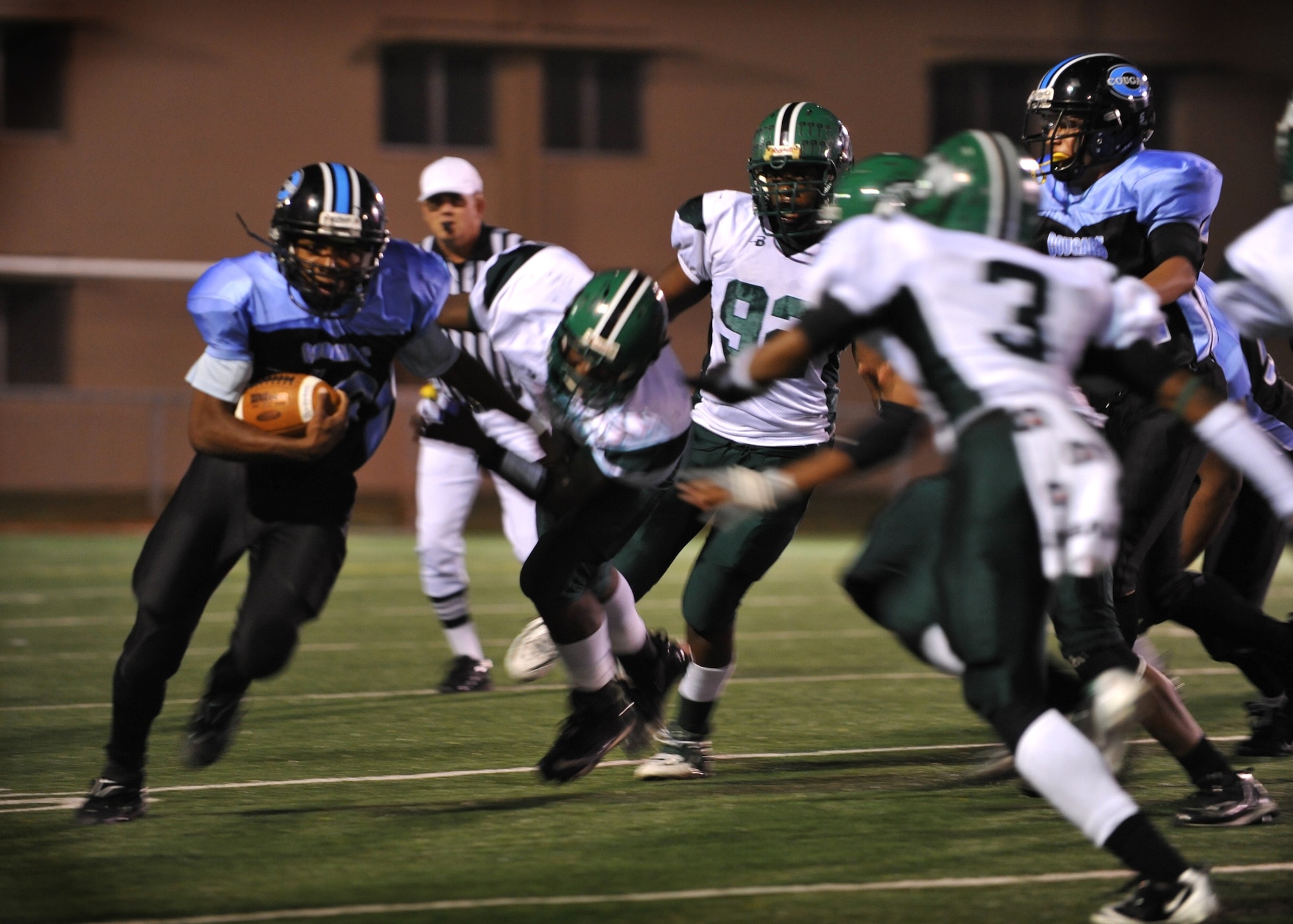 An Osan American High School football player runs past a Daegu American High School defender Oct. 15 at Osan Air Base.  The OAHS Cougars fell short 28-6 but will host their final and homecoming game Oct. 29. (U.S. Air Force Photo/Senior Airman Evelyn Chavez)