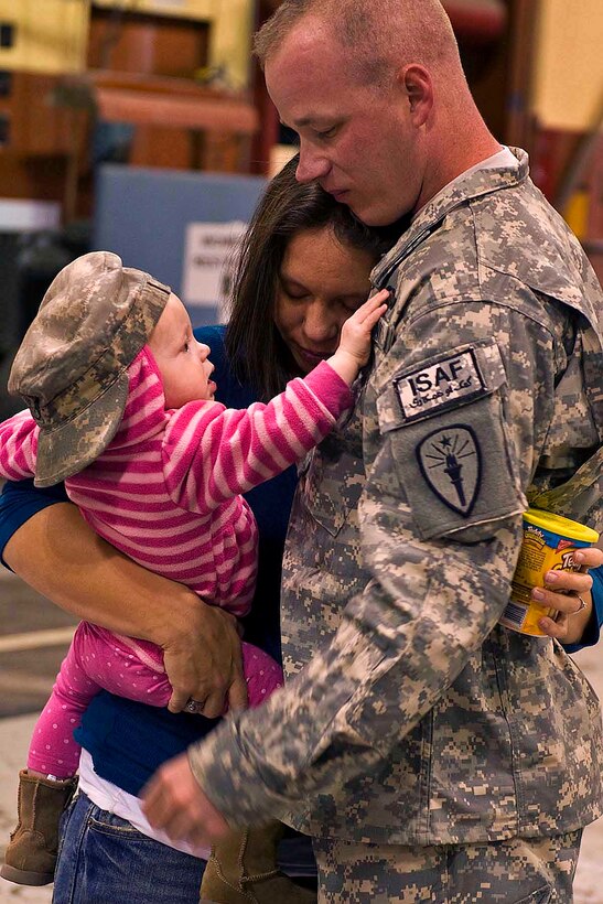 U.S. Army Staff Sgt. Robert Anderson embraces his family at Stout Field, Indianapolis, Oct. 20, 2010, after returning home from a yearlong deployment to Afghanistan. Anderson, an Indiana Guardsman, is an infantryman and operations sergeant assigned to the 2-19th Agribusiness Development Team.