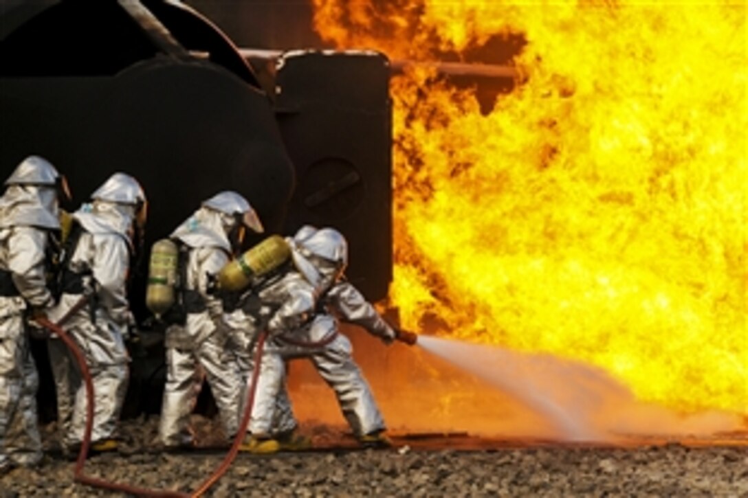 U.S. Air Force airmen extinguish an aircraft fire during a training exercise at the Phelps Collins Combat Readiness Training Center, Mich., Oct. 16, 2010. The airmen are assigned to the Ohio Air National Guard’s 180th Fighter Wing.
