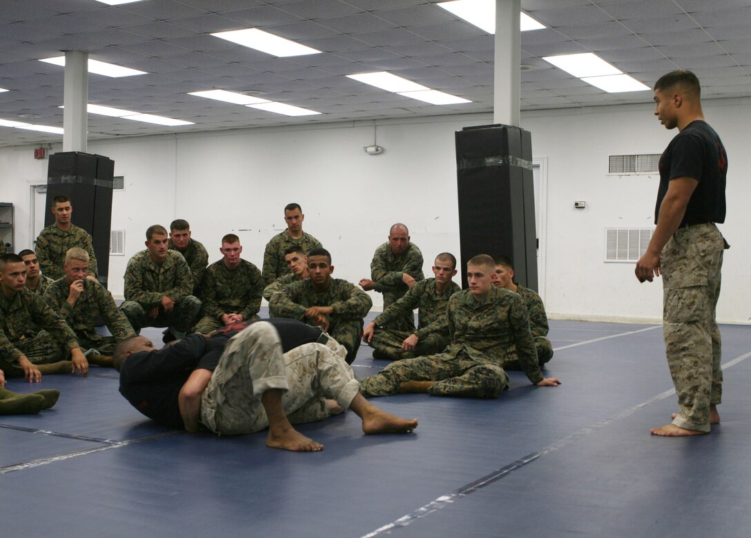 Staff Sgt. Daniel Sandlin, a martial arts instructor trainer with Advanced Infantry Training Battalion, speaks to his students as they watch two instructors grapple during a demonstration, at School of Infantry (East), Camp Geiger, N.C., Oct. 20, 2010. Sandlin and Sgt. Robert Abrantes, who is also an instructor trainer, both participate in mixed martial arts in addition to their responsibilities as Marine Corps leaders and martial arts instructors.