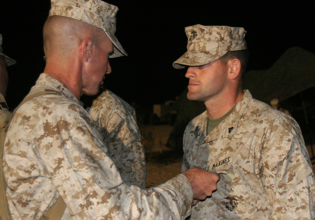 Corporal Michael Jackson, the regimental maintenance chief with Regimental Combat Team 8, receives the Navy Commendation Medal from Col. Eric Smith, the RCT-8 commanding officer, Oct. 20, at P111, Marine Corps Air Station Yuma, Ariz.  Jackson and two other Marines recieved the award for their actions in coming to the aid of a fellow Marine while with the Advance Party.