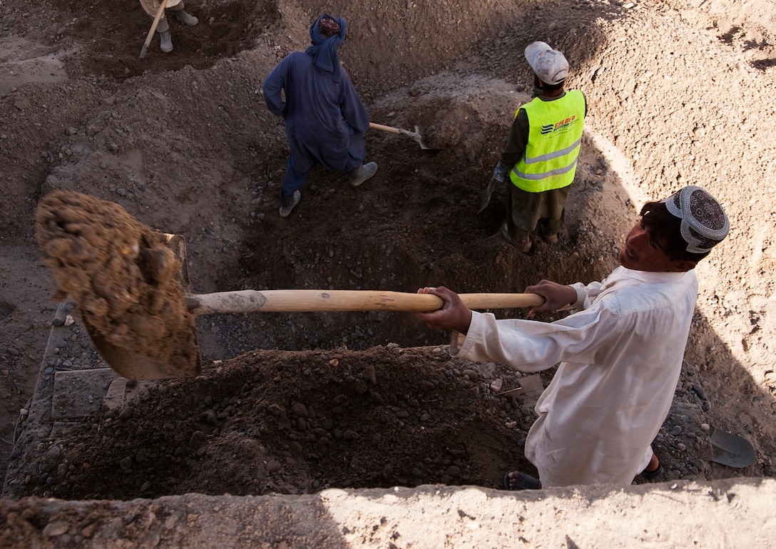 Abdul Raziq, an Afghan construction worker, shovels dirt onto the roof of an annex building in the Nawa District Governor’s Center in Nawa, Afghanistan, Oct. 21, 2010. Construction projects in the governor’s center have provided hundreds of Afghans with job opportunities.
