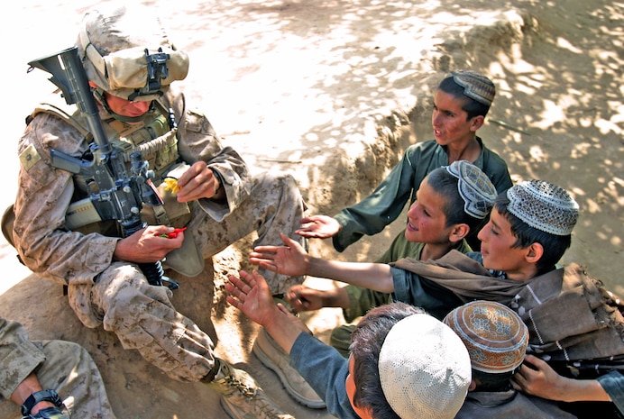 Lt. Col. James R. Fullwood, commanding officer of 2nd Battalion, 9th Marine Regiment, hands toys out to local Afghan children outside a shura during a during a clear, hold, and build operation, Oct. 21, in Northern Marjah, Afghanistan. The main purpose of the operation was established security for the construction of a new patrol base while conducting searches of local’s compounds in the area. Locals were invited to a centralized location where key Marine leaders were present to answer any questions or concerns they had about the operation.