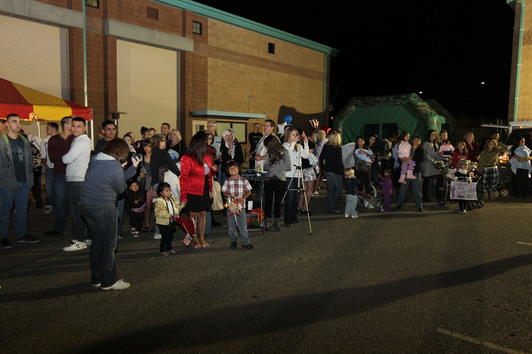 Family and friends eagerly gather in front of building 2081 as the buses carrying the Marines from 3rd Combat Engineers Battalion and Alpha Co., 1st Tank Battalion advanced party come into view Oct. 20, 2010.::r::::n::