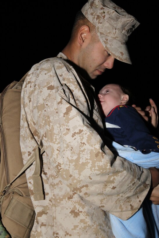 Corporal Joshua Glotzeecker, a motor transportation Marine with Company A, 1st Tank Battalion, holds his 3-month-old son, Zander, for the first time during 3rd Combat Engineer Battalion and Co. A, 1st Tank Battalion’s advanced party homecoming Oct. 20, 2010.::r::::n::