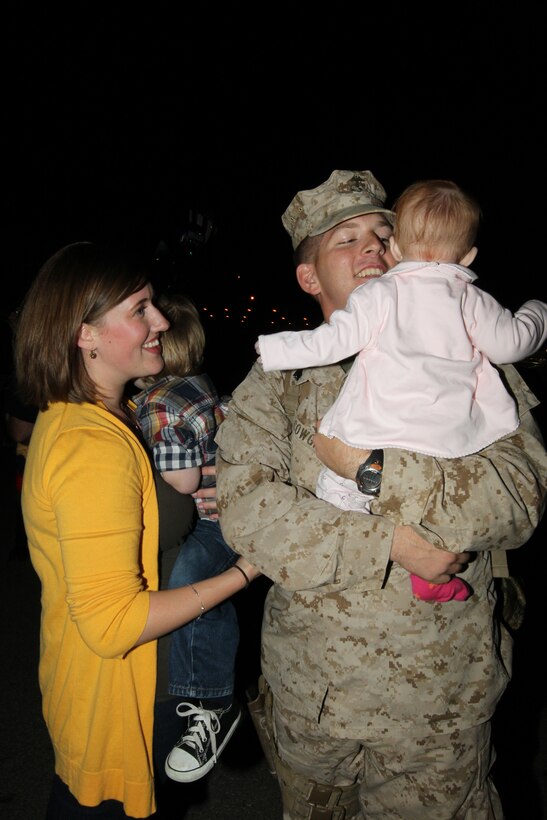Sergeant Jessie Cowgill, a vehicle commander with Company A, 1st Tank Battalion, holds his 5-month-old daughter, Willa, with his wife, Jena, and son, Oliver, during 3rd Combat Engineers Battalion’s and Co. A, 1st Tank Battalion’s advance party homecoming Oct. 20, 2010.