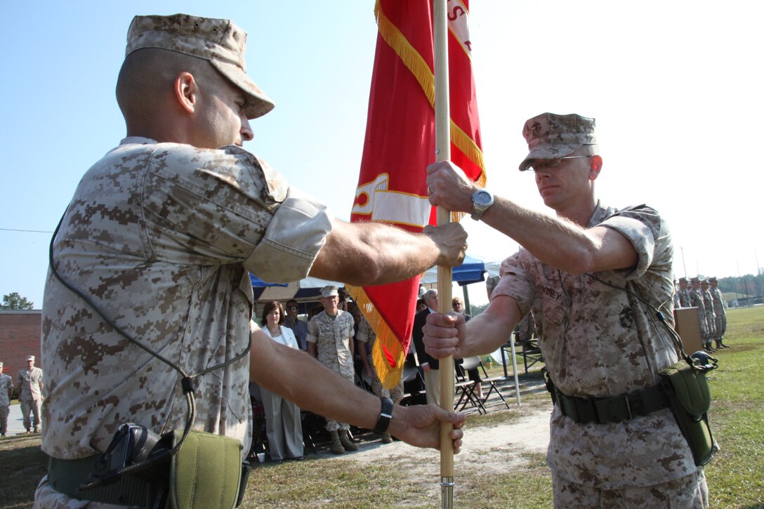 Lt. Col. Brian J. King, left, the outgoing commanding officer of Marine Wing Communications Squadron 28, passes off MWCS-28’s battle colors to his replacement, Lt. Col. Gregory T. Puntney, at a change of command ceremony here Oct. 21. King was the Spartan’s commanding officer for 18 months, in which the squadron spent time in Iraq, Afghanistan and various other training locations.