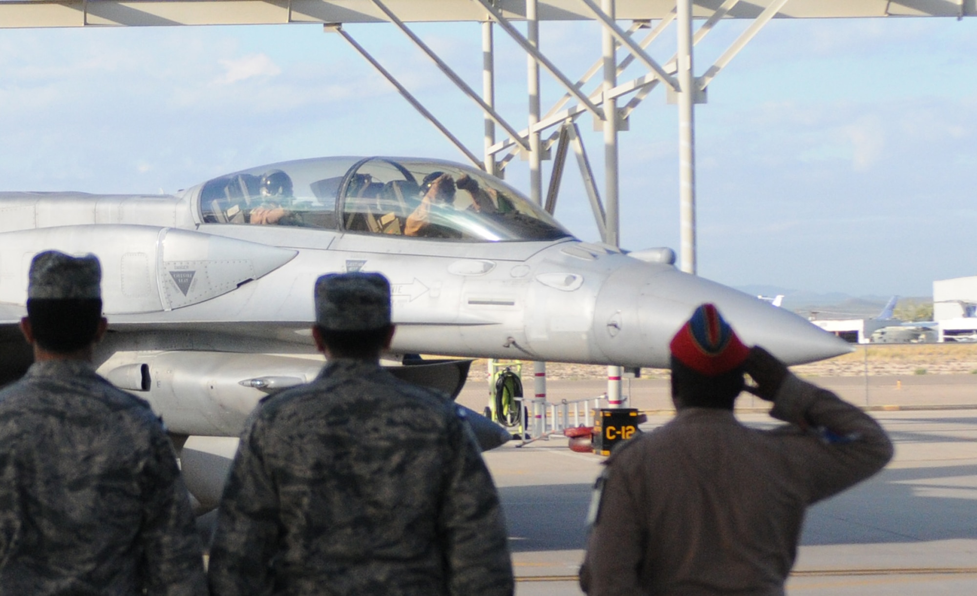 United Arab Emirates Air Force and Air Defense pilots and maintenance officers salute as an F-16F Desert Falcon taxis on the 162nd Fighter Wing flight line at Tucson International Airport for the last time Oct. 20. Five of 13 UAE fighters stationed here since 2004 for training began the journey home while the rest will follow over the next month. (US Air Force photo/Maj. Gabe Johnson)