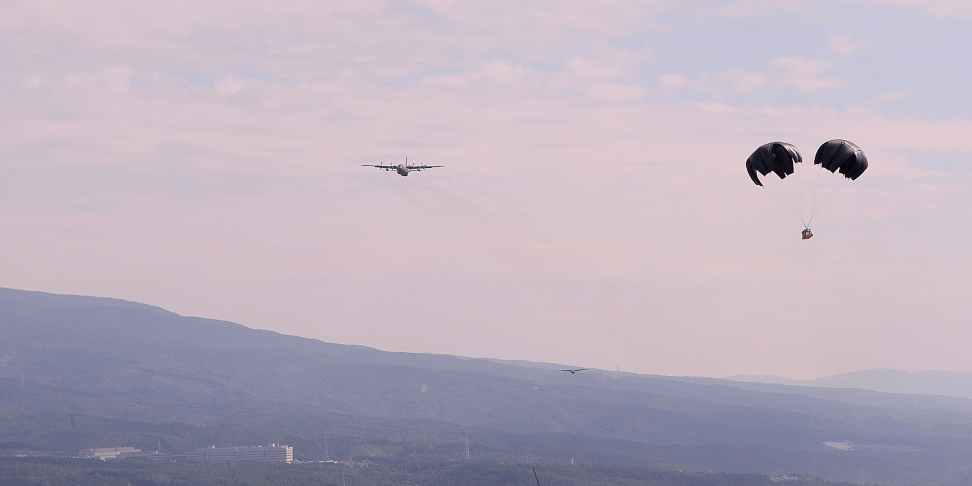 A cross parachute carries a cargo load dropped out of a C-130 Hercules during a practice of the low-cost, low-altitude drop technique Oct. 7, 2010, at the Fuji Drop Zone in Japan. Sergeant Anderson is assigned to the 374th Logistic Readiness Squadron combat mobility flight. (U.S. Air Force photo/Airman 1st Class Katrina R. Menchaca) 
