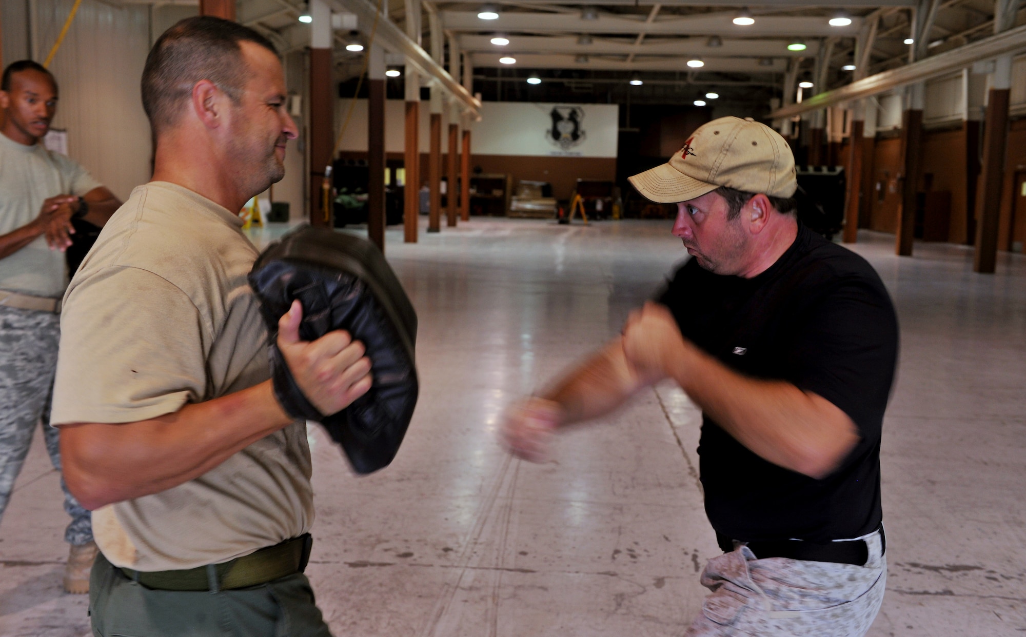 MOODY AIR FORCE BASE, Ga. -- During Krav Maga training, Lt. Joseph Dukes, Lowndes County Sheriff’s Department Special Weapons and Tactics team leader and training coordinator, punches a bag held by Steve Jarrmaillo, Lowndes County Sheriff’s Department reserve deputy,  during a timed combat session here Oct. 14. One part of training for Krav Maga is conditioning, before practicing a technique, instructors lead members through a vigorous conditioning session. (U.S. Air Force photo/Airman 1st Class Joshua Green)