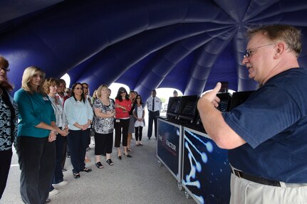 Randolph AFB, TX, 21 Oct 2010:  Steven Johnson (r), who escorts NASCAR number 19 Elliott Sadler to NASCAR races and air shows West of the Mississippi, explains the kiosks that quiz participants on Air Force trivia and allow local recruiters to contact possible recruits, to spouses attending the AETC Commanders and Command Chiefs conference. 
(U.S. Air Force photo/Steve Thurow)