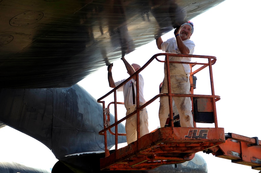 BARKSDALE AIR FORCE BASE, La. -- Contractors Donnie Manning (right) and Edward Smith sands off the paint of a B-52D bomber Oct. 15 at the Eighth Air Force Museum. Many contractors are working to restore the aircraft to its original paint and condition. This particular bomber flew in Operation Linebacker II during the Vietnam War. (U.S. Air Force photo/Staff Sgt. John Gordinier)