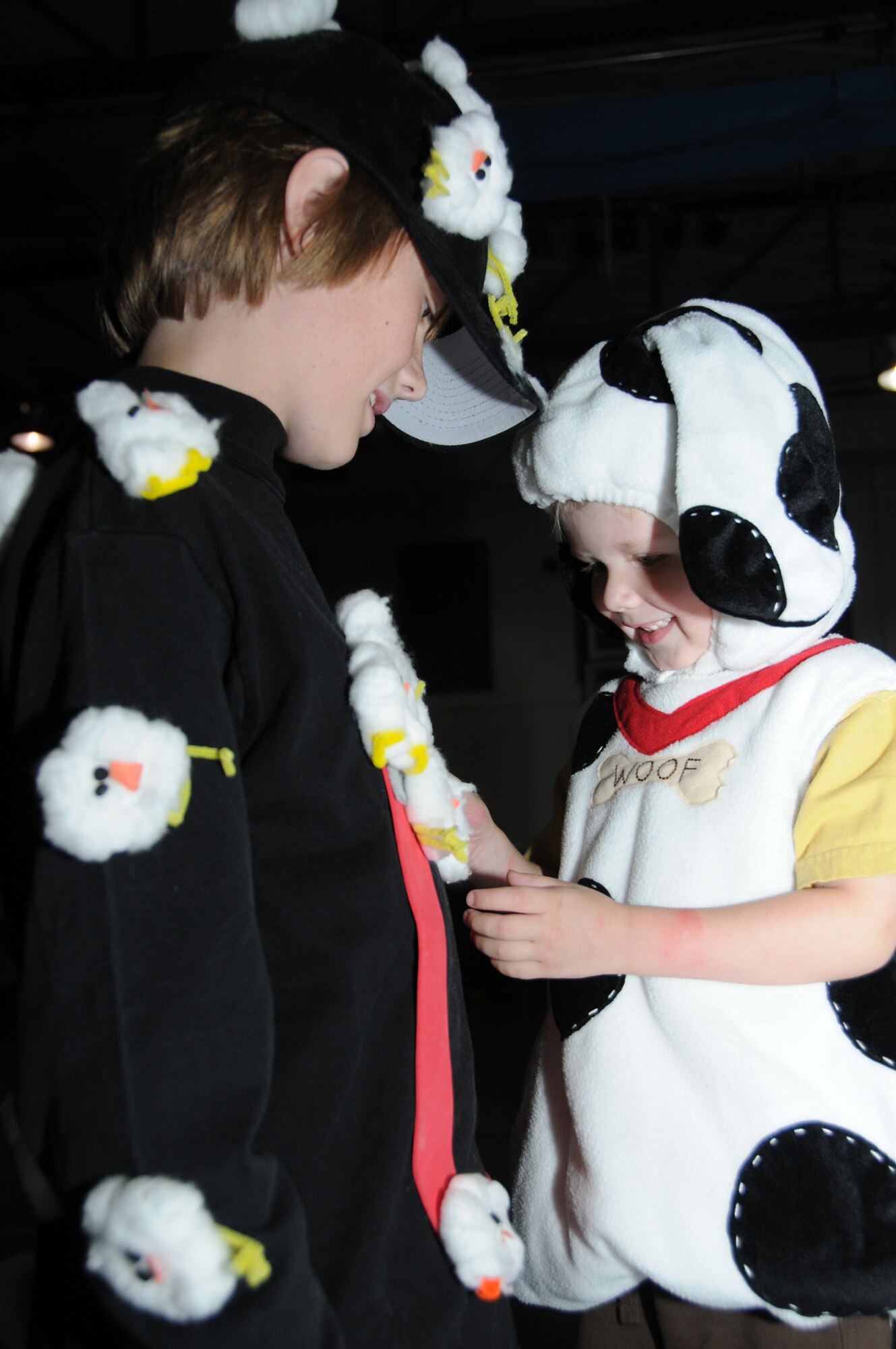 Parker Zurbrugg, 12, shows his 3-year-old brother, Logan, dressed as a puppy, his  “chick magnet” attire that won the costume contest at Spooktacular, Saturday’s
Halloween party for children whose parents are deployed. Their parents are Maj. Karl and Melissa Zurbrugg, 81st Training Wing.  The event, sponsored at the youth center by the airman  and family readiness center, also included games and refreshments. (U.S. Air Force photo by Kemberly Groue)