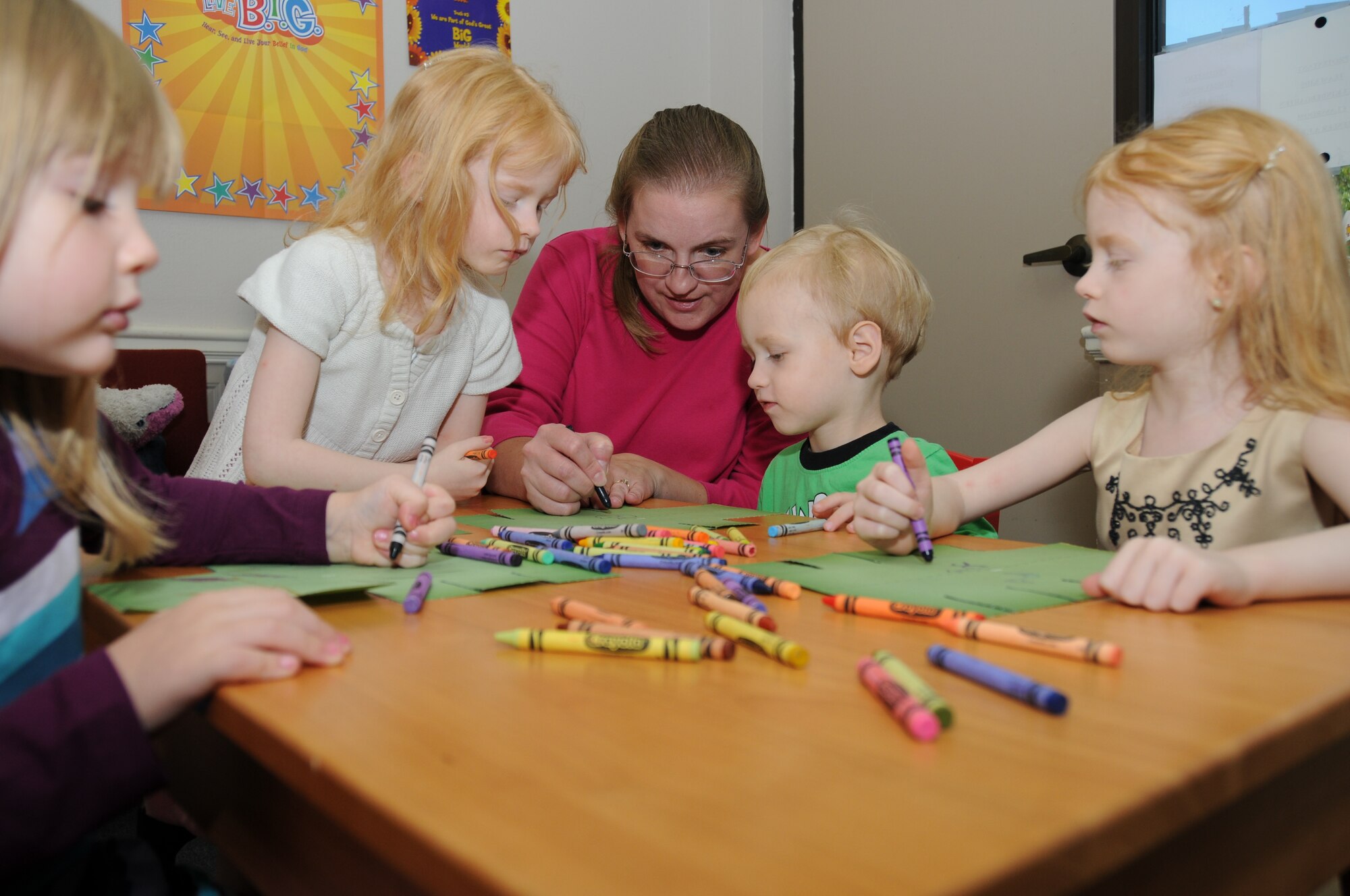 Jennifer Mallory, center, wife of Chaplain (Capt.) Charles Mallory, leads a lesson at Sunday’s Protestant Children’s Church. From left, Jennalyn Mallory, 3, joins Beth Janton, 6; Beth’s brother Sammy, 3, and Beth’s twin, Milena, in coloring palm tree cutouts. Tech. Sgt. Mike and Celena Janton, 338th Training Squadron, are Beth, Sammy and Milena’s parents.  (U.S. Air Force photo by Kemberly Groue)