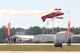 Sean D. Tucker performs a low level high speed stunt in his Oracle Challenger bi-plane cutting a ribbon flying between two banners held by volunteers. (U.S. Air Force Photo/Don Peek)