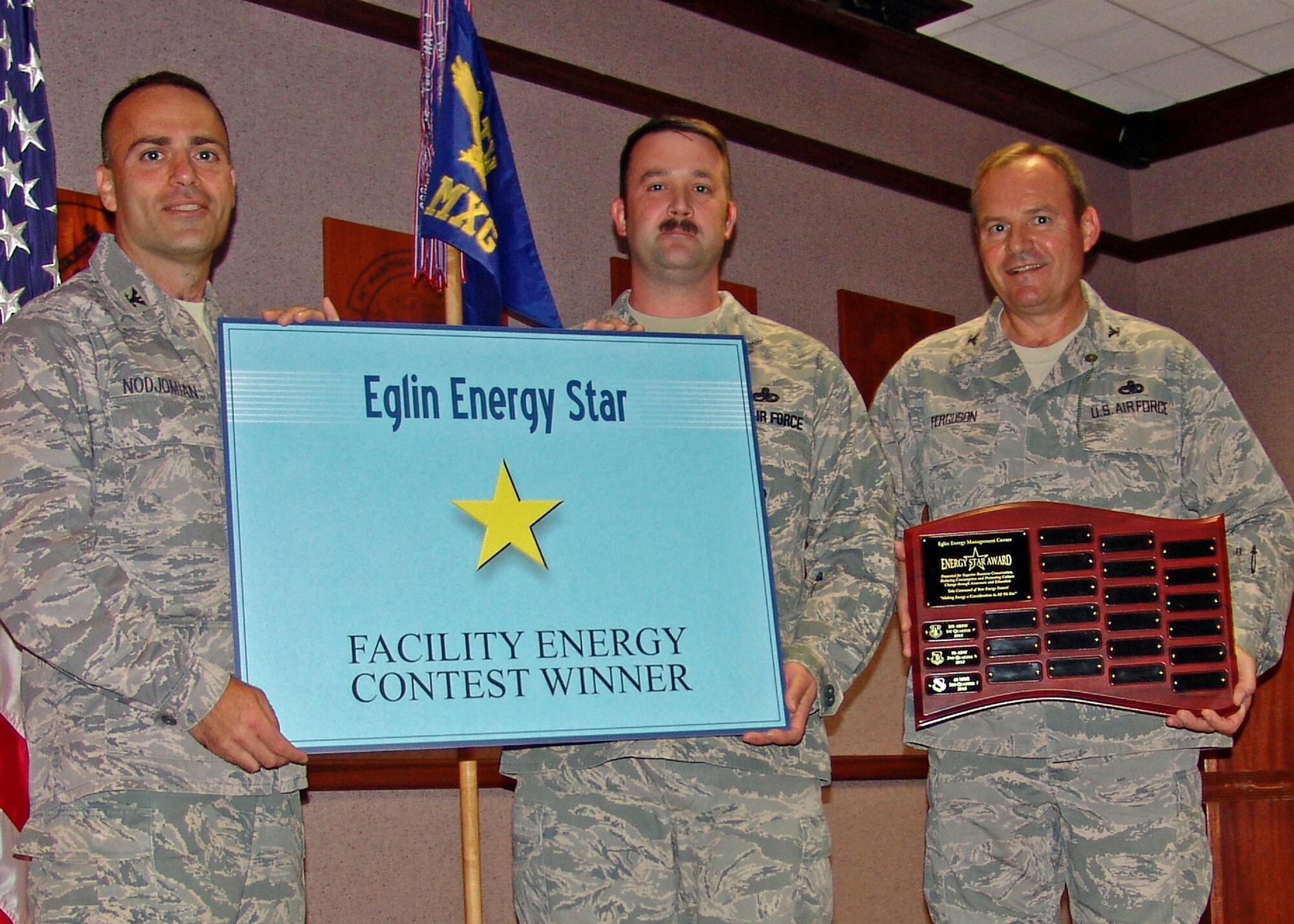 Col. Sal Nodjomian, 96th Air Base Wing commander, presents a plaque and poses with Master Sgt. Craig Sargent and Col. Glenn Ferguson, 46th Maintenance Group commander, for winning the third quarter energy challenge. Their building (Bldg. 100) realized a 15 percent reduction in energy use over the Labor Day weekend and saved over $4,000.  (Courtesy photo)