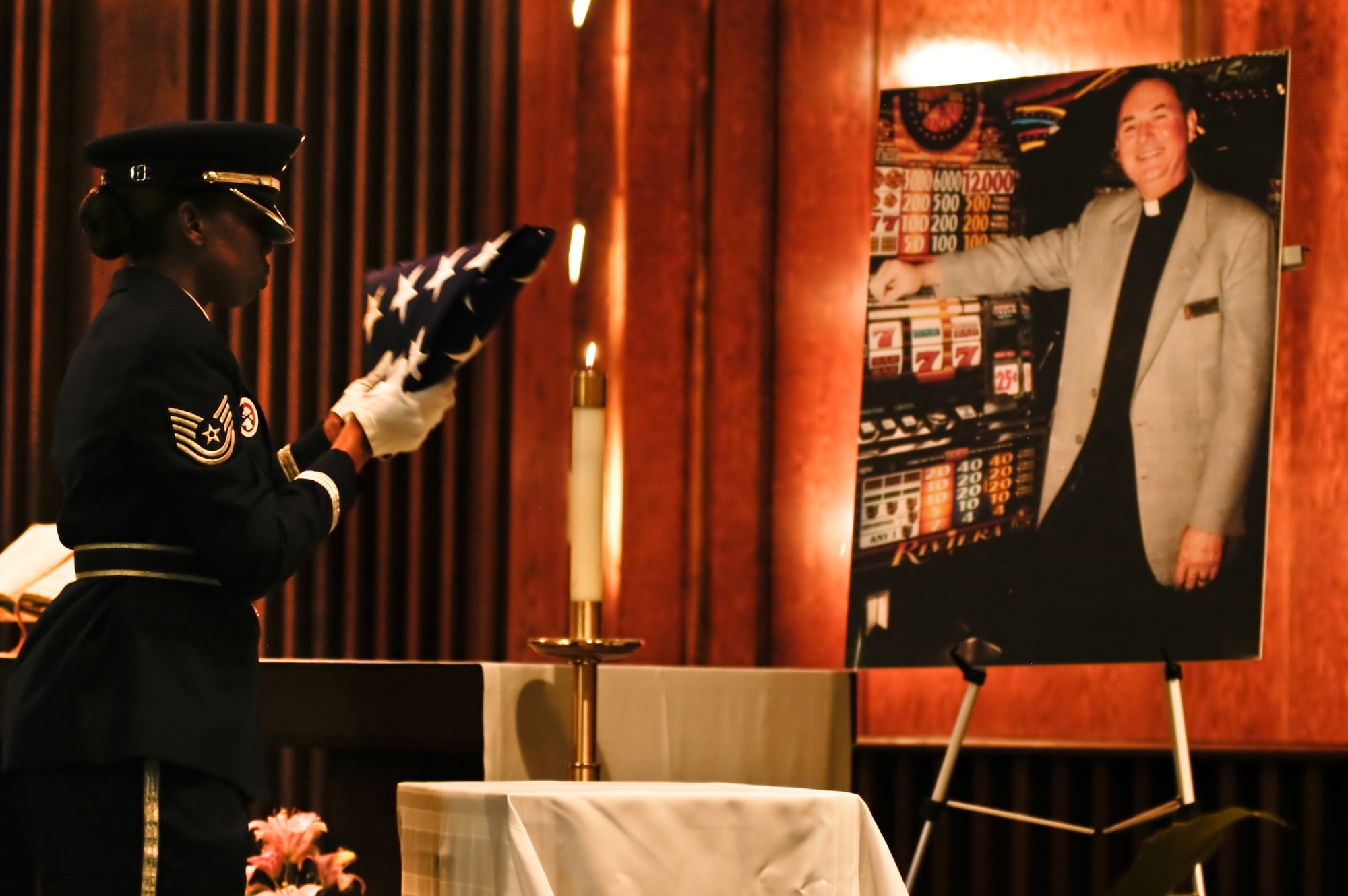 ROBINS AIR FORCE BASE, Ga. -- Tech. Sgt. Tiffany Jackson, Robins AFB Honor Guard flight sergeant, places a flag in front of a photo of Chaplain (Col.) Charles M. Bolin during his memorial service Oct. 14, 2010 in the base chapel. Chaplain Bolin was serving with the Yellow Ribbon Campaign at Air Force Reserve Command headquarters. He suffered a heart attack Sept. 21 while on temporary duty at Joint Base Andrews, Md. In his civilian capacity, he was a chaplain for a major Las Vegas casino.  (U.S. Air Force photo by Staff Sgt. Alexy Saltekoff)