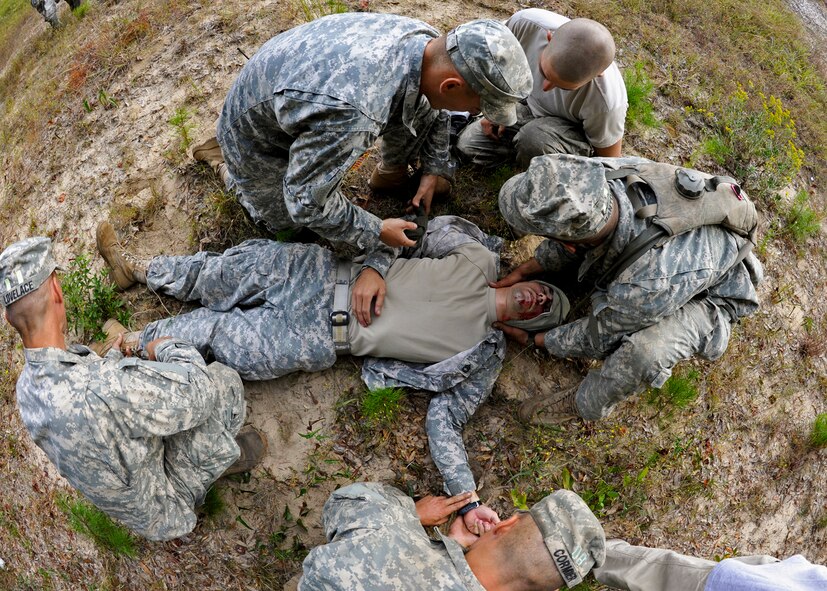 Army Rangers try to determine the correct treatment to a fellow wounded Soldier's injuries after a simulated bus accident Oct. 19 at the entrance to their camp on Eglin Air Force Base. The no-notice exercise simulated an accident involving two cyclists and a bus transporting 6th Ranger Training Battalion students. Soldiers following in the other buses reacted quickly to secure the scene while getting medical support from Eglin and local emergency crews. (U.S. Air Force photo/Samuel King Jr.)