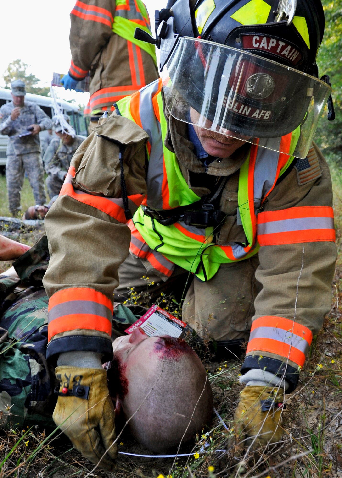 An Eglin firefighter places an injury tag around one of the simulated victims of a bus accident Oct. 19 at the entrance to the 6th Ranger Training Battalion on Eglin Air Force Base. The no-notice exercise simulated an accident involving two cyclists and a bus transporting Ranger students. Soldiers following in the other buses had to react and secure the scene while getting medical support from Eglin and local emergency crews.  (U.S. Air Force photo/Samuel King Jr.)