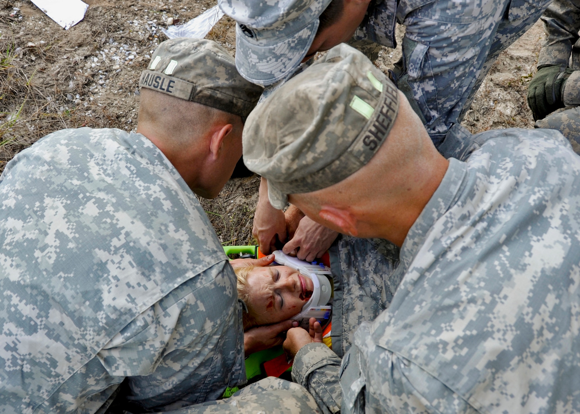 Army Rangers secure a cyclist's injured neck during a simulated bus accident Oct. 19 at the entrance to their camp on Eglin Air Force Base. The no-notice exercise simulated an accident involving two cyclists and a bus transporting 6th Ranger Training Battalion students. Soldiers following in the other buses reacted quickly to secure the scene while getting medical support from Eglin and local emergency crews.  (U.S. Air Force photo/Samuel King Jr.)