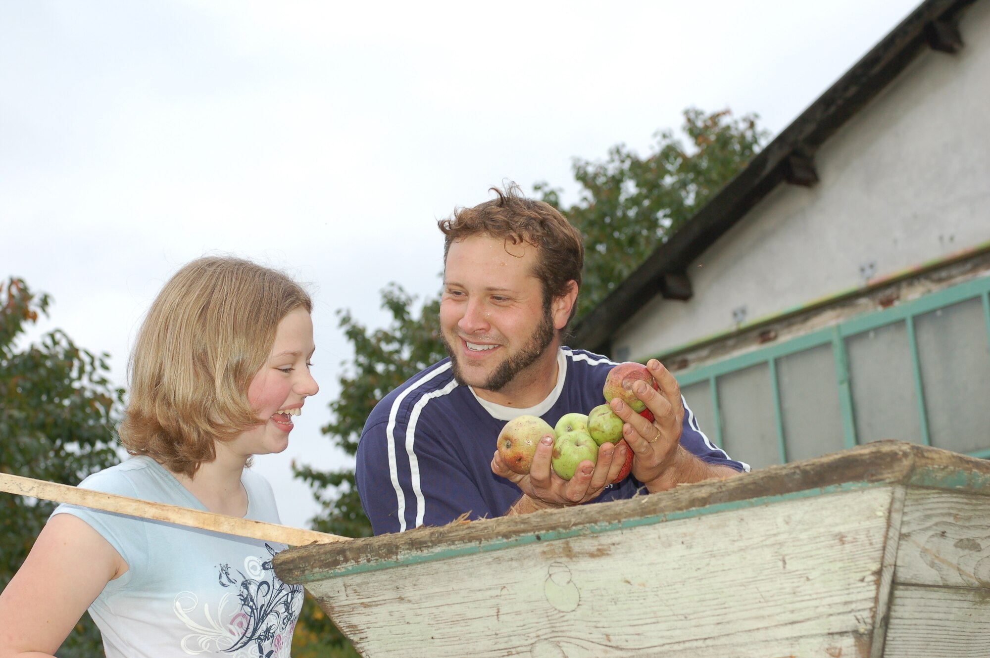 OSANN-MONZEL, Germany—The vintner, Vito Cipolla, holds up a hand-full of fresh apples in front of Kaylynn Burtcher, one of the 20 homeschooling children who recently attended a field trip to Osann- Monzel . (U.S. Air Force photo/Iris Reiff)