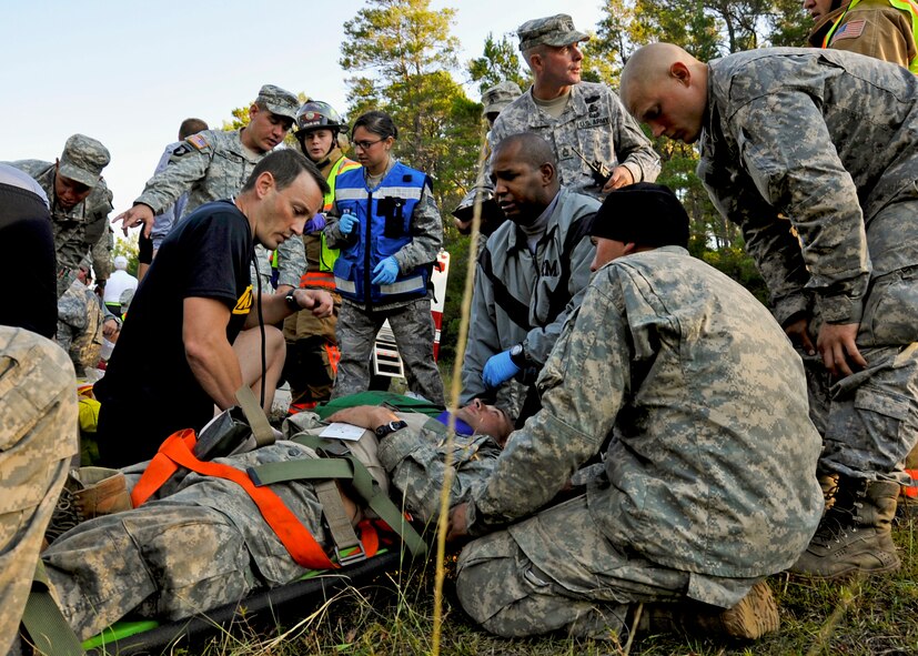 Army Rangers and medics interact with Eglin paramedics and firefighters at the scene of a simulated bus accident Oct. 19 at the entrance to the Ranger Camp road.  The no-notice exercise simulated an accident involving two cyclists and a bus carrying 6th Ranger Training Battalion students.  The Soldiers following in the other buses had to react and secure the scene while getting medical support from Eglin and local emergency crews.  (U.S. Air Force photo/Samuel King Jr.)