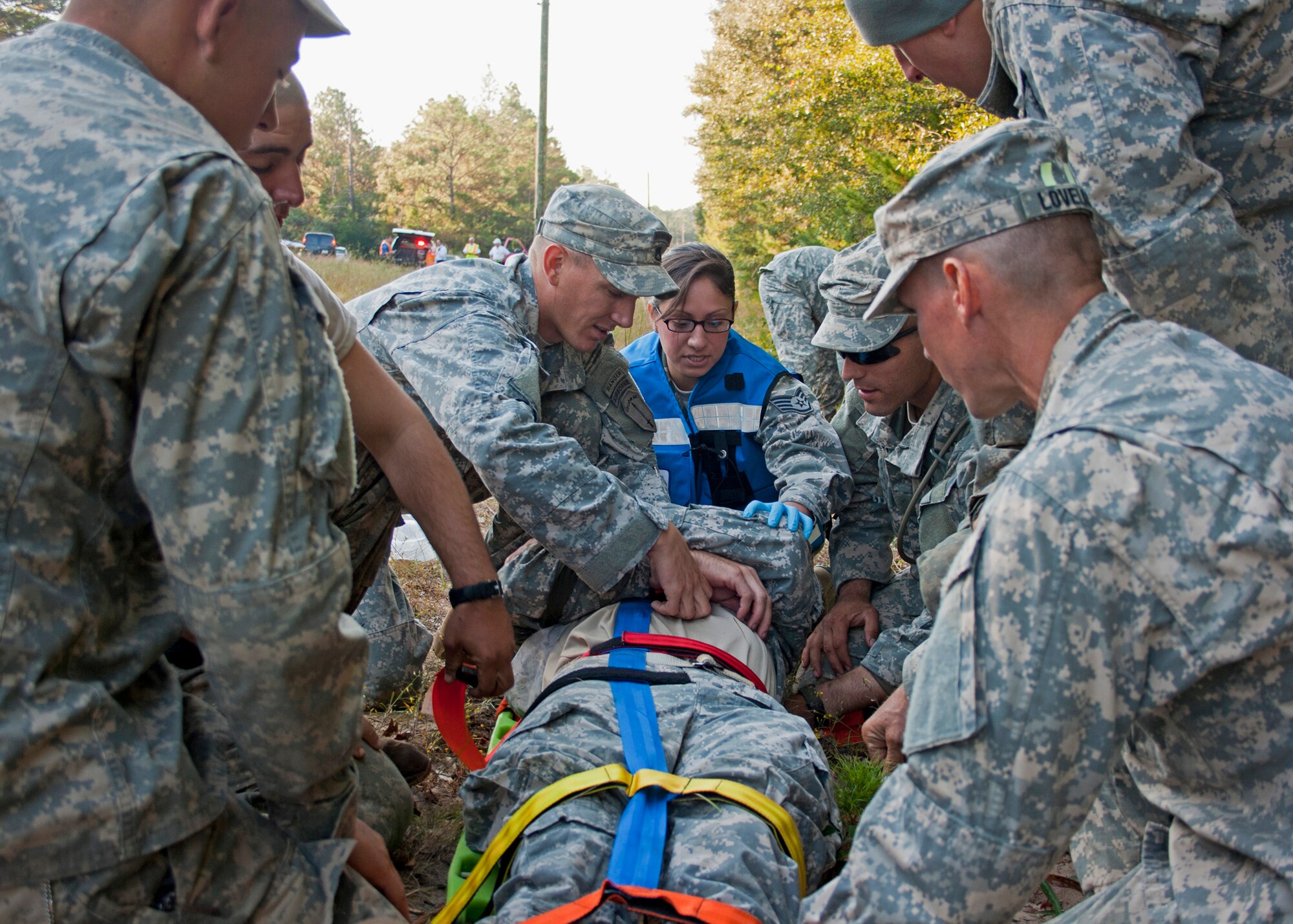 Army Rangers work with Air Force paramedics following a simulated bus accident Oct. 19 at the entrance to the Ranger Camp road.  The no-notice exercise simulated an accident involving two cyclists and a bus carrying 6th Ranger Training Battalion students.  The Soldiers following in the other buses had to react and secure the scene while getting medical support from Eglin and local emergency crews.  (U.S. Air Force photo/2nd Lt. Andrew Caulk)