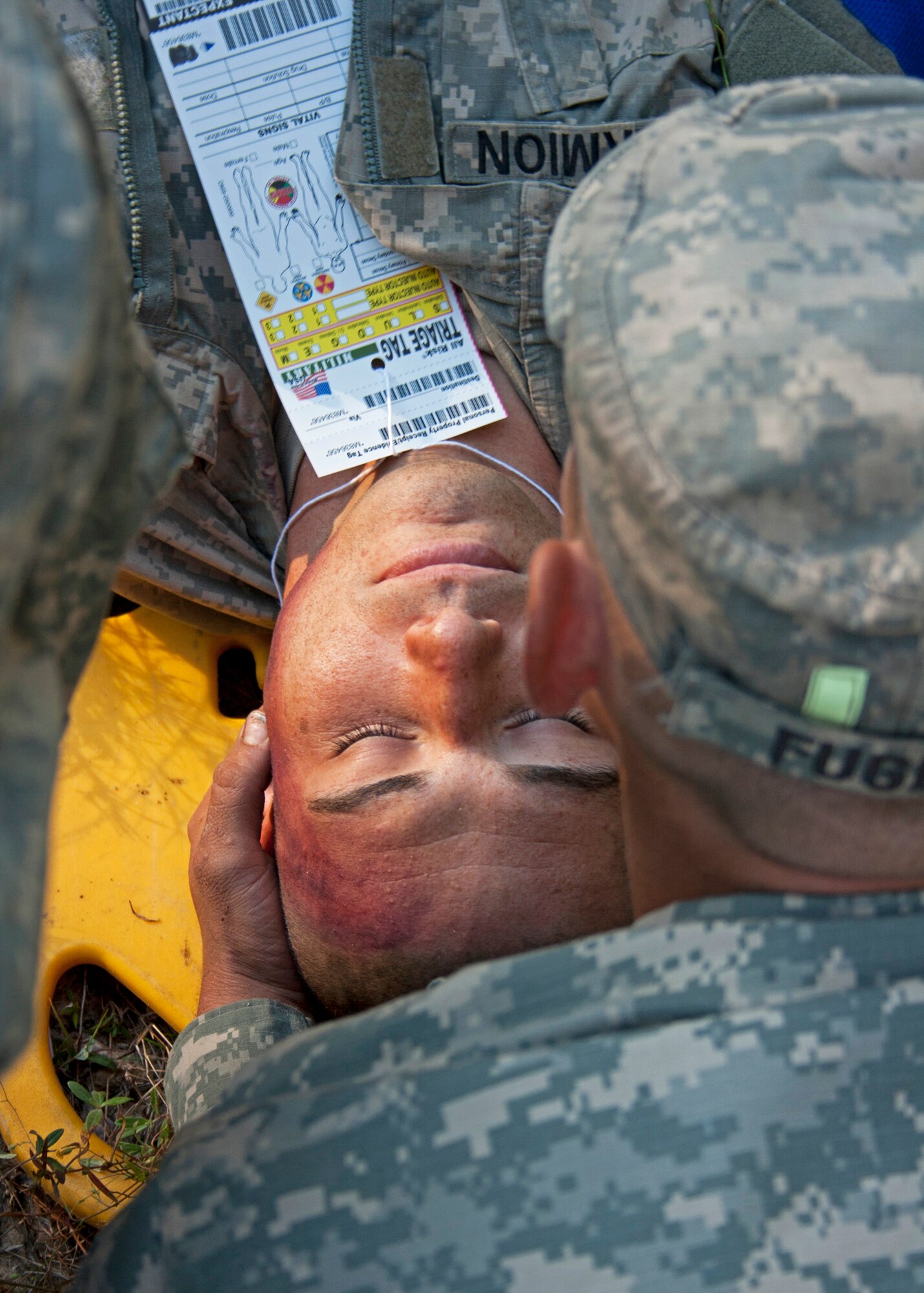 An Army Ranger secures the neck of a fellow Soldier after a simulated bus accident Oct. 19 at the entrance to the Ranger Camp road.  The no-notice exercise simulated an accident involving two cyclists and a bus carrying 6th Ranger Training Battalion students.  The Soldiers following in the other buses had to react and secure the scene while getting medical support from Eglin and local emergency crews.  (U.S. Air Force photo/2nd Lt. Andrew Caulk)
