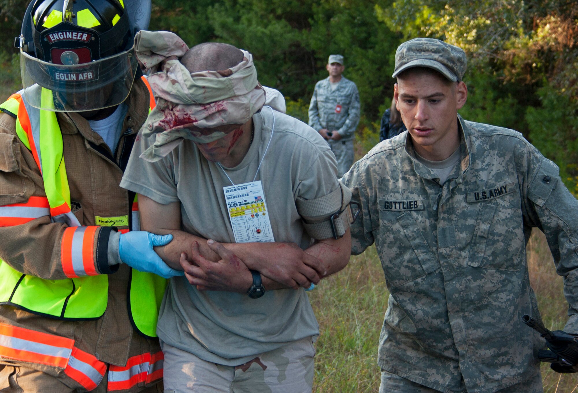 An Eglin firefighter and an Army Ranger help move a wounded victim during a simulated exercise Oct. 19 at the entrance to the Ranger Camp road.  The no-notice exercise simulated an accident involving two cyclists and a bus carrying 6th Ranger Training Battalion students.  The Soldiers following in the other buses had to react and secure the scene while getting medical support from Eglin and local emergency crews.  (U.S. Air Force photo/2nd Lt. Andrew Caulk)