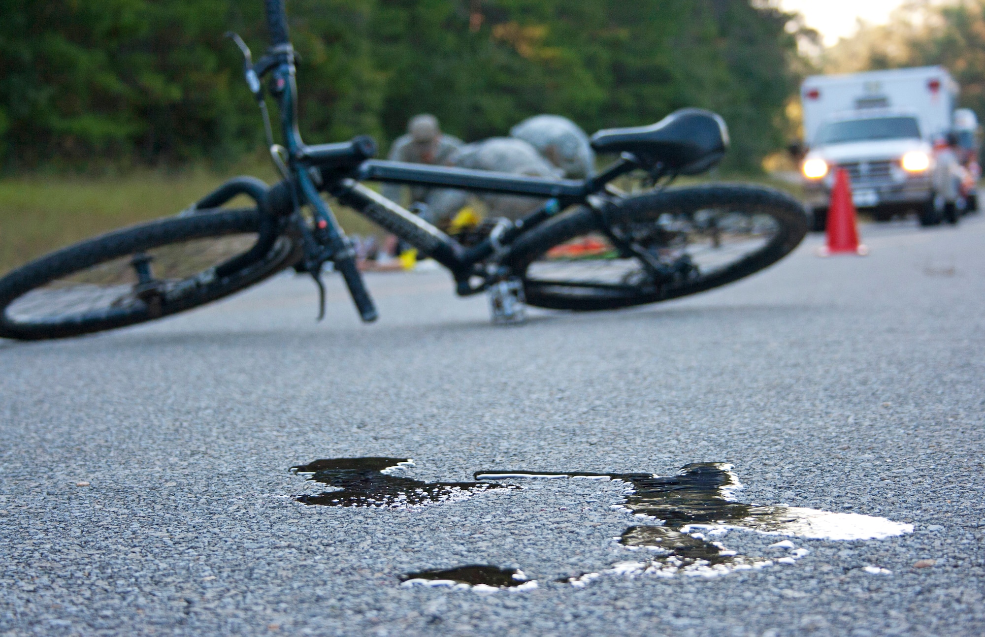 Soldiers provide aid to a cyclist hit by a bus during a simulated exercise as an ambulance from Eglin Air Force Base arrives Oct. 19 at the entrance to the Ranger Camp road.  The no-notice exercise simulated an accident involving two cyclists and a bus carrying 6th Ranger Training Battalion students.  The Soldiers following in the other buses had to react and secure the scene while getting medical support from Eglin and local emergency crews.  (U.S. Air Force photo/2nd Lt. Andrew Caulk)