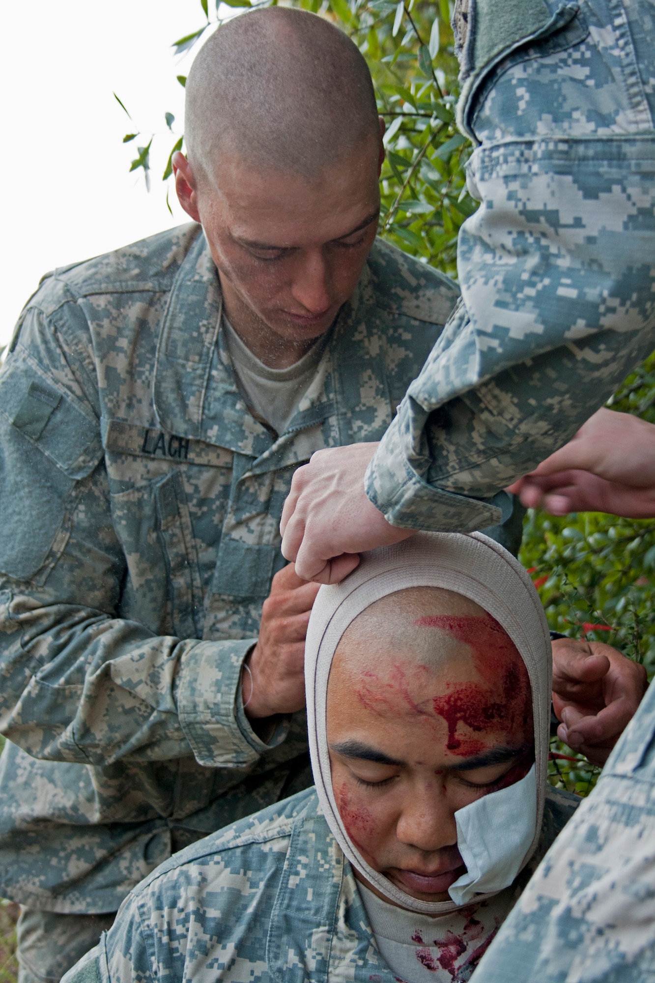 Soldiers attend to the head wound of a fellow soldier after a simulated bus accident Oct. 19 at the entrance to the Ranger Camp road.  The no-notice exercise simulated an accident involving two cyclists and a bus carrying 6th Ranger Training Battalion students.  The Soldiers following in the other buses had to react and secure the scene while getting medical support from Eglin and local emergency crews.  (U.S. Air Force photo/2nd Lt. Andrew Caulk)