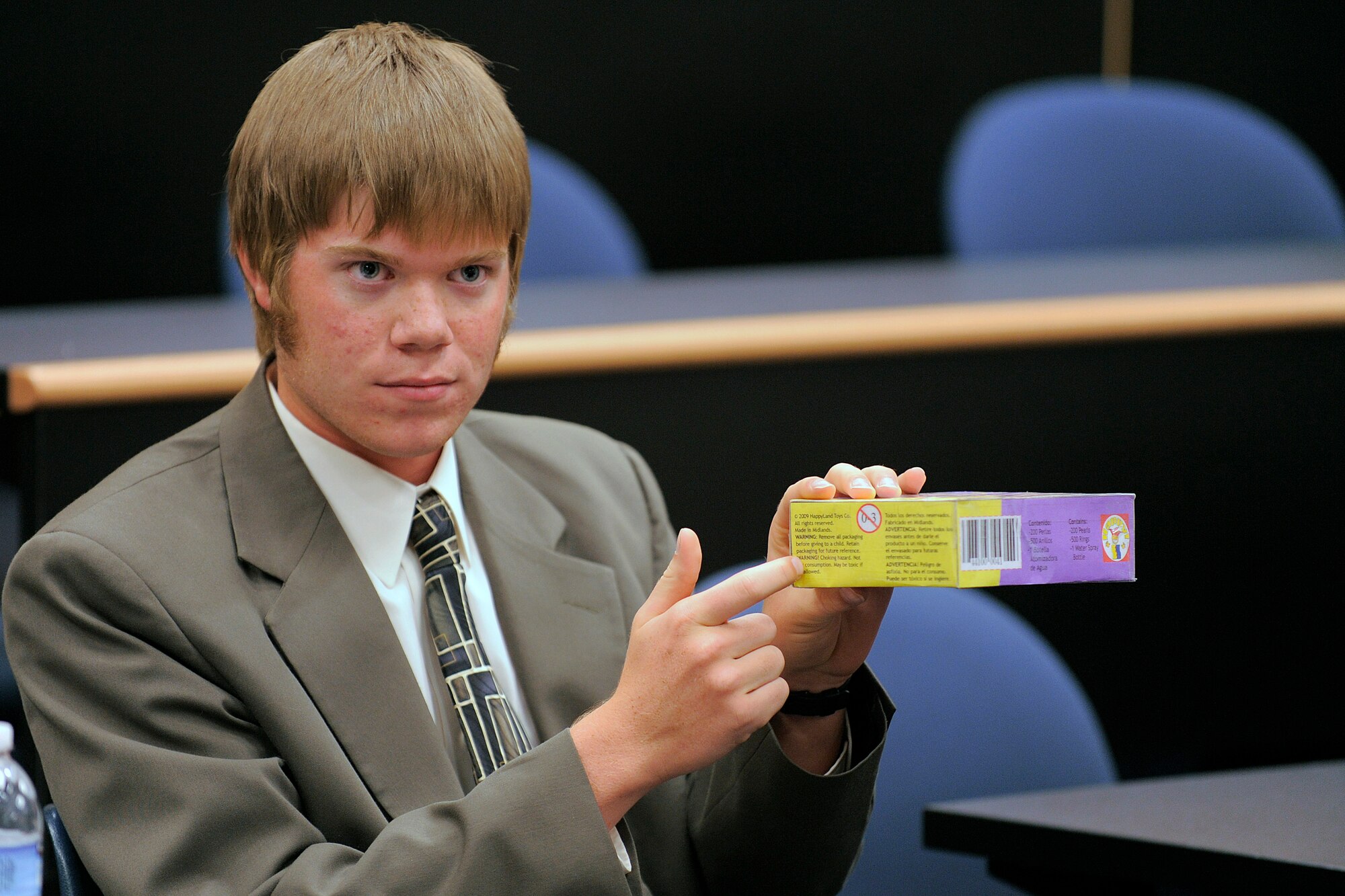 David Tomlinson emphasizes a choking hazard warning on a HappyLand Toys Co. box during a mock trial at the Air Force Academy Oct. 17, 2010. The HappyLand mock trial case involved a child who had died after choking on a small object contained in the box. Mr. Tomlinson is a student at the University of Colorado in Colorado Springs. (U.S. Air Force photo/Mike Kaplan)