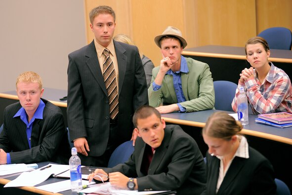 Cadet 2nd Class Clayton Schmitt, standing, listens to a judge's remarks during a mock trial at the Air Force Academy Oct. 17, 2010. Cadet Schmitt was part of the Academy's "New Kids on the Block" mock trial team, which also included, clockwise from bottom right: Cadets 3rd Class Jessica Norrington, Max Stanley and Brett Teague, Cadet 2nd Clsas Diana Bennett (seated behind Cadet Schmitt), Cadet 3rd Class Josh Williams and Cadet 4th Class Melanie Daugherty. (U.S. Air Force photo/Mike Kaplan)