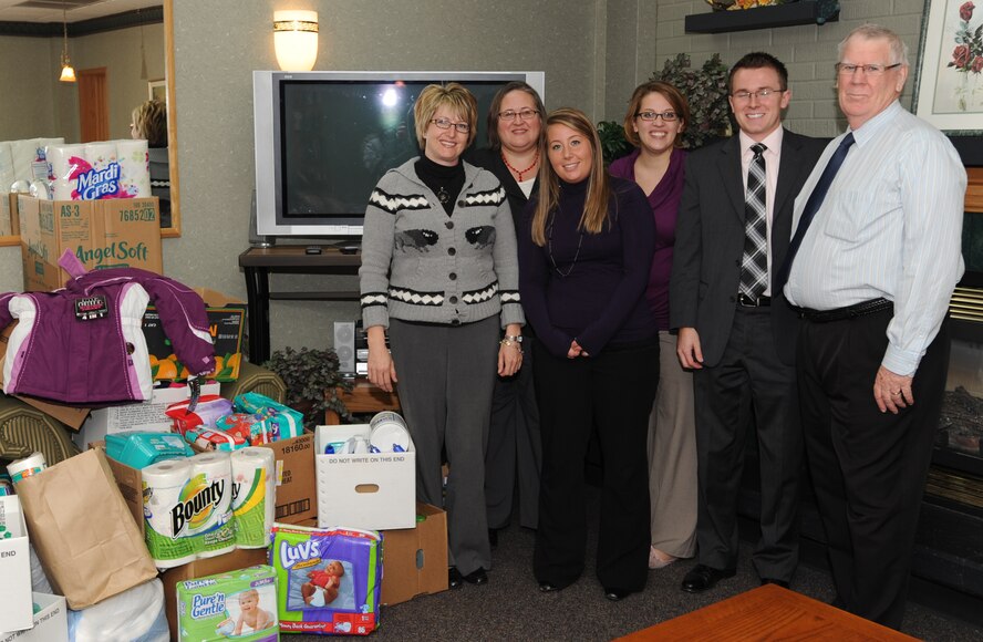 Members of the Community Violence Intervention Center of Grand Forks, N.D., pose next to the newly donated items from the Grand Forks Air Force Base Spouses’ Club and Family Advocacy donation drive Oct. 20 at the Community Activities Center here. More than 500 items were collected and donated to the CVIC. (U.S. Air Force photo by Staff Sgt. Suellyn Nuckolls)