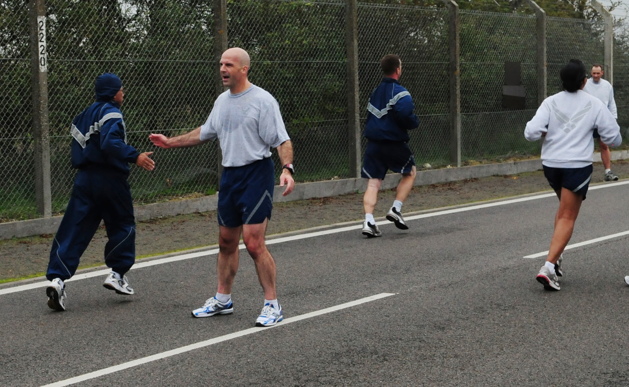 RAF MILDENHALL, England -- Col. Chad Manske, 100th Air Refueling Wing commander, (second left) gives words of encouragement to Team Mildenhall members heading towards the finish line at the wing 5K run Oct. 15. The run, held monthly, promotes health, fitness and camaraderie among base members. Some spouses, children and pets also take part in the run. (U.S. Air Force photo/Karen Abeyasekere)