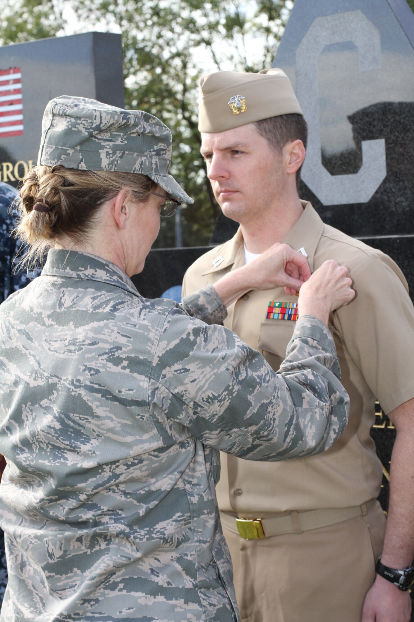 US Air Force Col. Michele M. Cook, Commander, Intelligence and Knowledge Development Directorate-Molesworth pins the new Information Dominance Warfare Officer insignia on Navy Lt. Joseph M. Hatfield.  