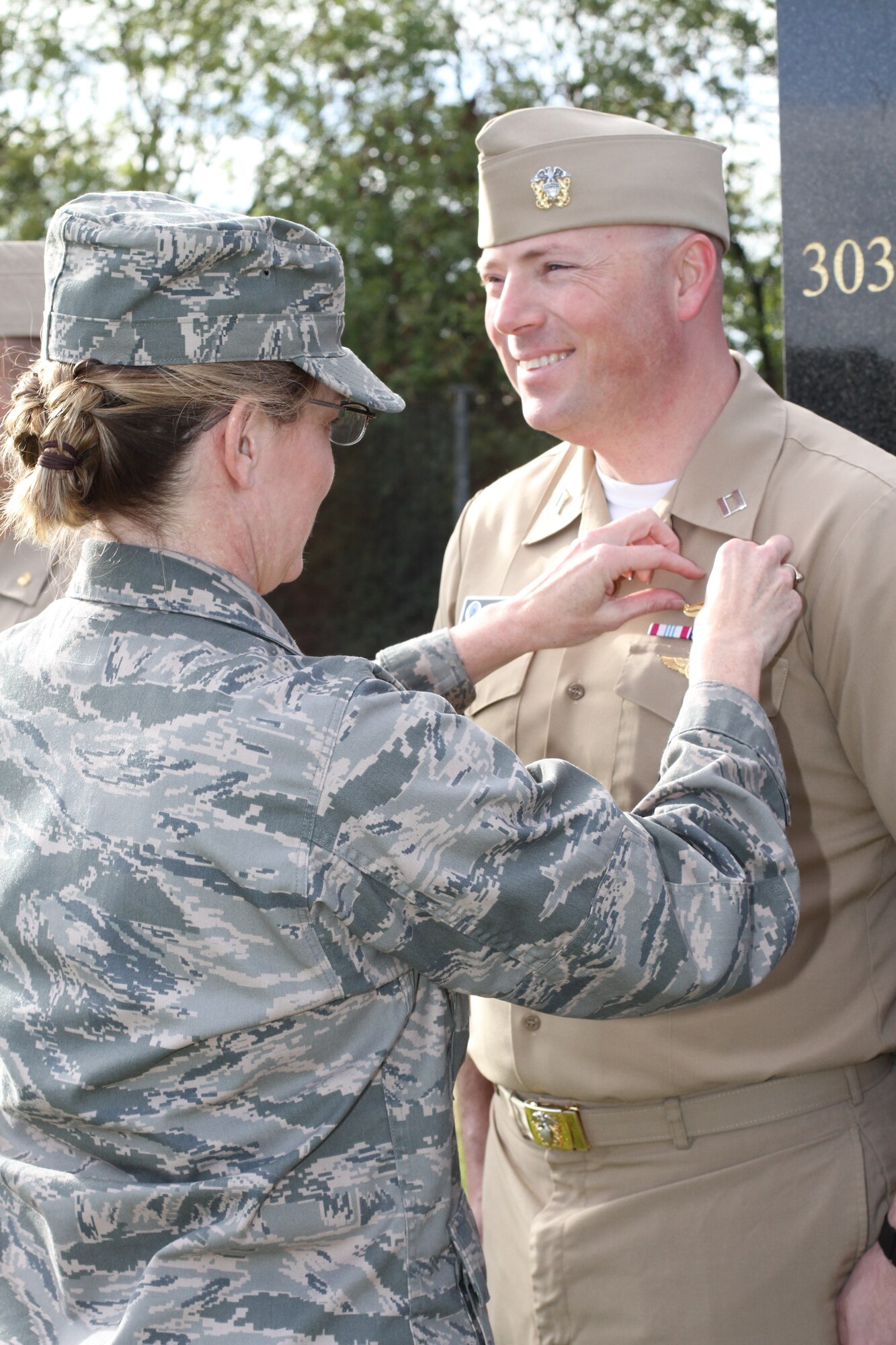 US Air Force Col. Michele M. Cook, Commander, Intelligence and Knowledge Development Directorate-Molesworth pins the new Information Dominance Warfare Officer insignia on Navy Lt. Andrew T. Hill.  Hill was among eight other Navy officers to be pinned.