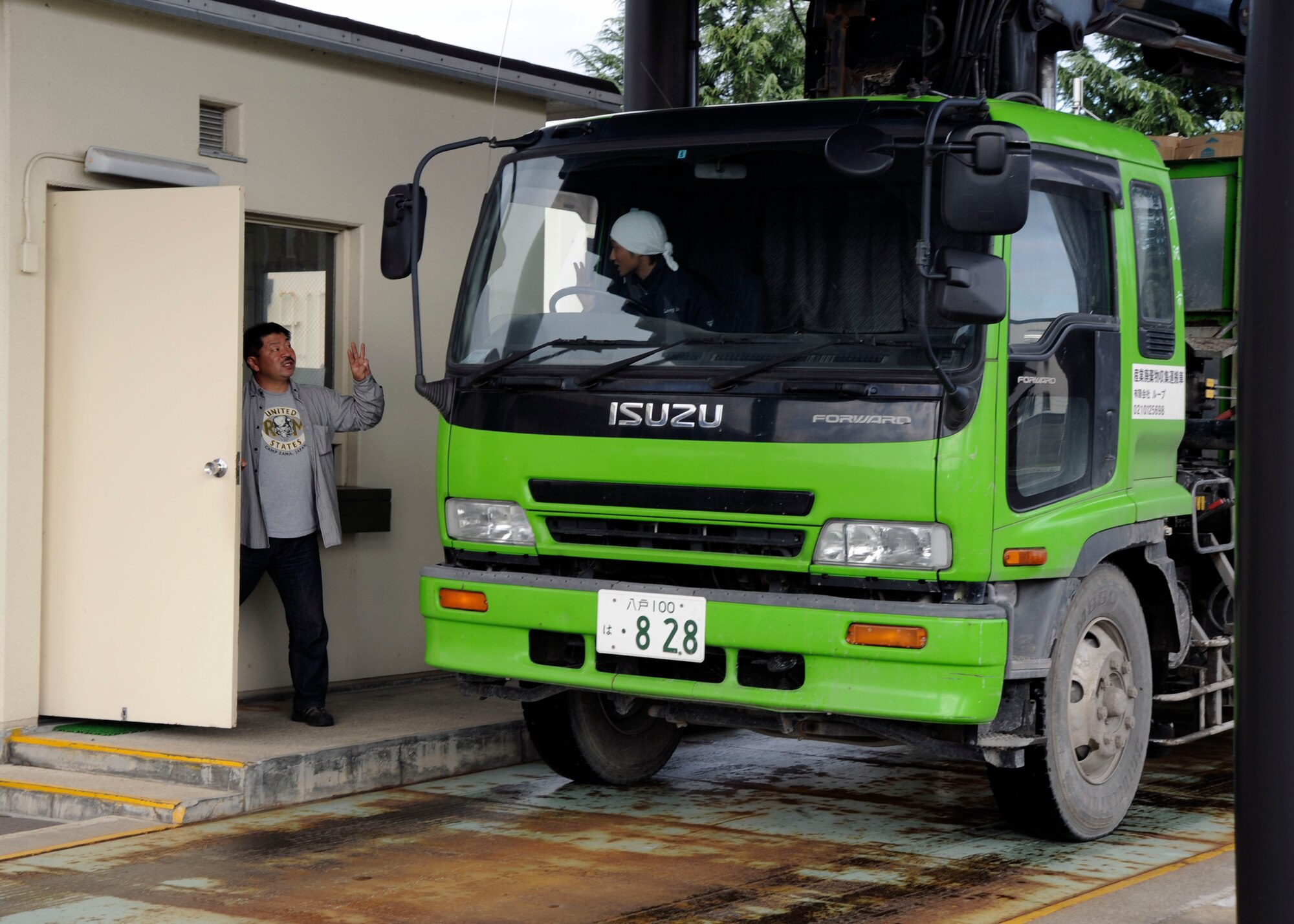 Yukie Yoshida, left, discusses a truck load of discarded cardboard, with the driver at Misawa Air Base, Japan, Oct. 21, 2010. Defense Reutilization and Marketing Office is open for all war-fighters and other base customers, needing to dispose of excess duty-related property. (U.S. Air Force photo by Tech. Sgt. Russell McBride/Released)