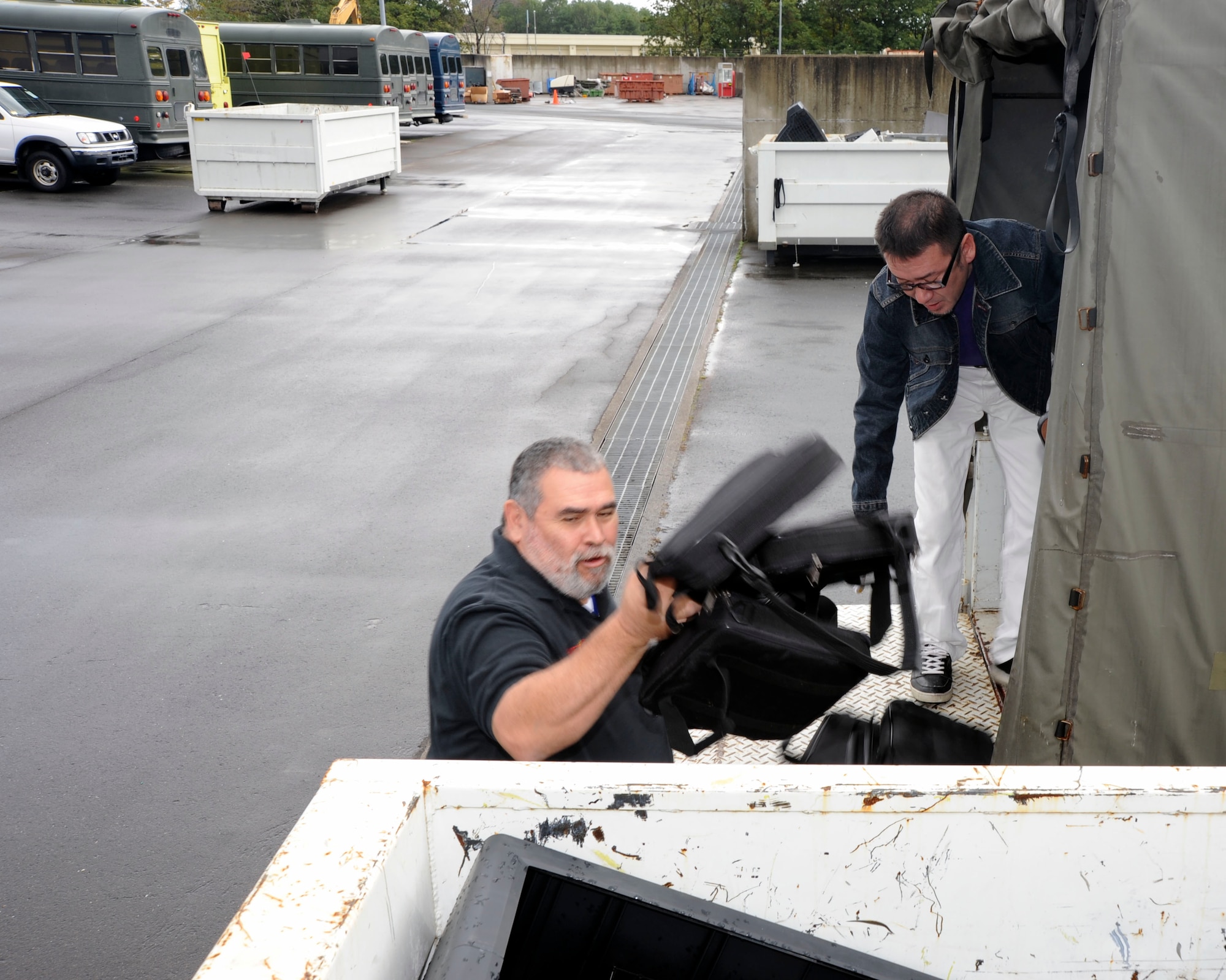Stanley Herrera, left, and Kazuya Saito, right, Sollars Elementary School employees, unload old and broken property from the school at Misawa Air Base, Japan, Oct. 21, 2010. The school administration regularly upgrades outdated equipment, enhancing the quality of life for Misawa families. (U.S. Air Force photo by Tech. Sgt. Russell McBride/Released)