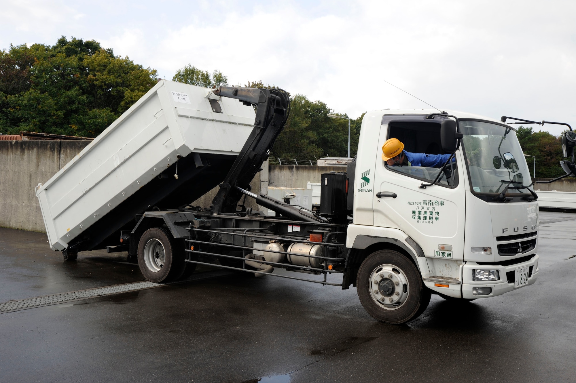 Akir Ishiwatr, Defense Reutilization and Marketing Office section, loads a dumpster of scrap wood onto a truck at Misawa Air Base, Japan, Oct. 21, 2010. DRMO falls under the Defense Logistics Agency, which is part of a global community that operates field sites in 41 states and 16 foreign countries. (U.S. Air Force photo by Tech. Sgt. Russell McBride/Released)