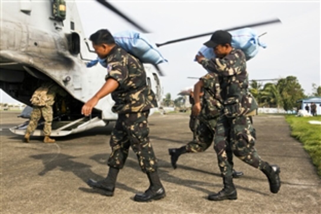 Philippine troops load bags of rice into a U.S. CH-46 Sea Knight helicopter during relief efforts with help from U.S. Marines in Isabela province, Philippines, Oct. 21, 2010. The Marines are assigned to the 31st Marine Expeditionary Unit. The Philippine government requested assistance from the Marine unit after Super Typhoon Juan caused death, injury and damage throughout the area.