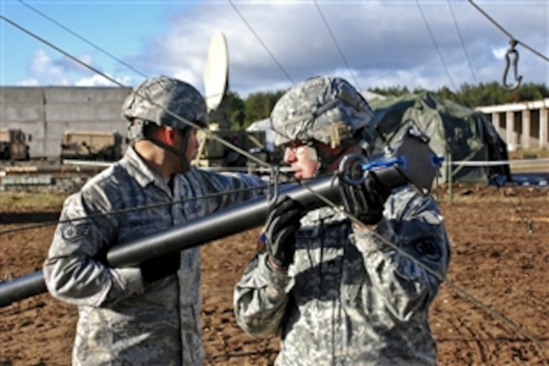 U.S. Air Force Staff Sgt. Jordan Sanchez, left, and U.S. Army Staff Sgt. Christopher Ernst set up the broadcast antenna for the American Forces Network Europe Tactical Mobile Radio and Television System during Exercise Saber Strike, a U.S. Army Europe event, on the Adazi Training Area, Latvia, Oct. 18, 2010.