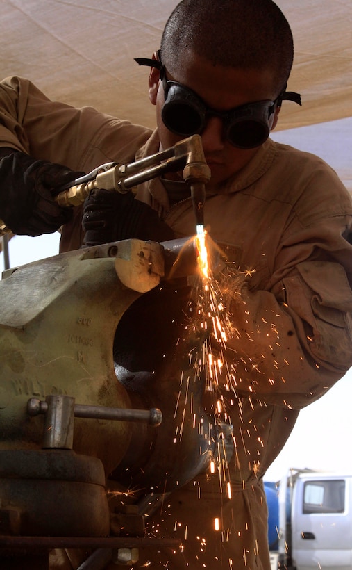 Lance Cpl. Alex Navarro, a metal worker with Support Company, Combat Logistics Battalion 3, 1st Marine Logistics Group (Forward), repairs pieces of machinery that will be used on heavy equipment vehicles at Camp Dwyer, Afghanistan, Oct. 21. Navarro, a native of El Monte, Calif., believes he can benefit from working with Marines from Combat Logistics Regiment 15 (Forward).