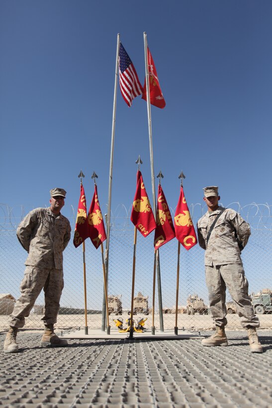 Sgt. John Leavens (left) and Lance Cpl. Devin Reyna, Marines with Combat Logistics Battalion 2, 1st Marine Logistics Group (Forward), stand proudly in front of the flag poles they constructed displaying the National Colors and Marine Corps flag in the CLB-2 compound at Camp Leatherneck, Afghanistan, Oct. 19. The Marines volunteered several weeks of their time to gather materials and construct the flag poles to display the colors with pride.