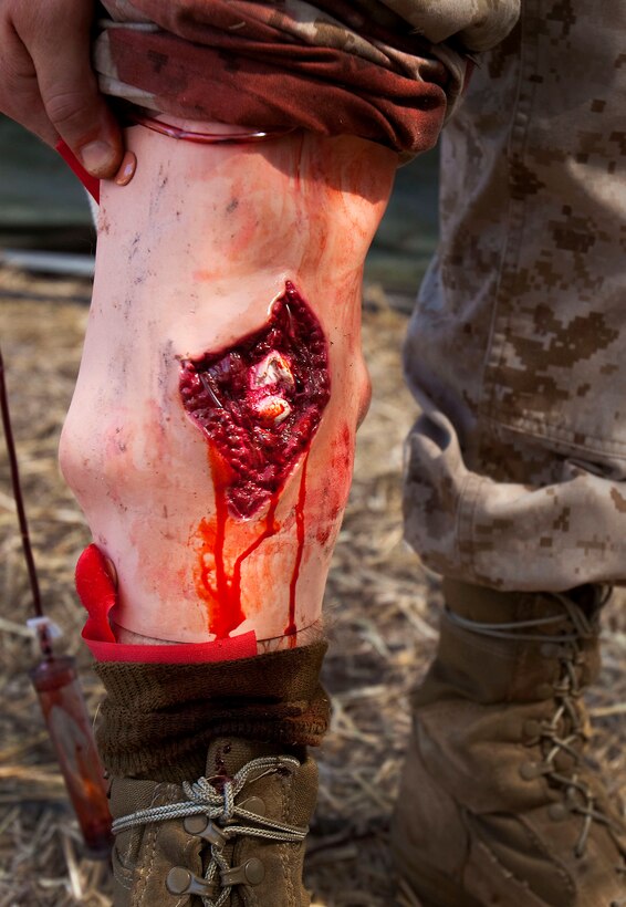 Cpl. Nathaniel Wright, Gunnery Sgt. Joseph Maupai, and Lance Cpl. Travis Corley, assigned to Headquarters and Service Company, 3rd Radio Battalion, assess simulated casualty Petty Officer 3rd Class Dennis Amos, a corpsman with 21st Dental Company, during a mass casualty evacuation drill at Dillingham Air Field in Mokuleia, Hawaii, Oct. 21. The drill, part of a battalion-level field exercise held at the air field, Oct. 18 to 27, was designed to prepare the battalion for future combat operations, and sustain core competencies in combat lifesaver support and first aid, said Capt. Jonathan Cartrett, company commander, H&S Co., 3rd Radio Bn.