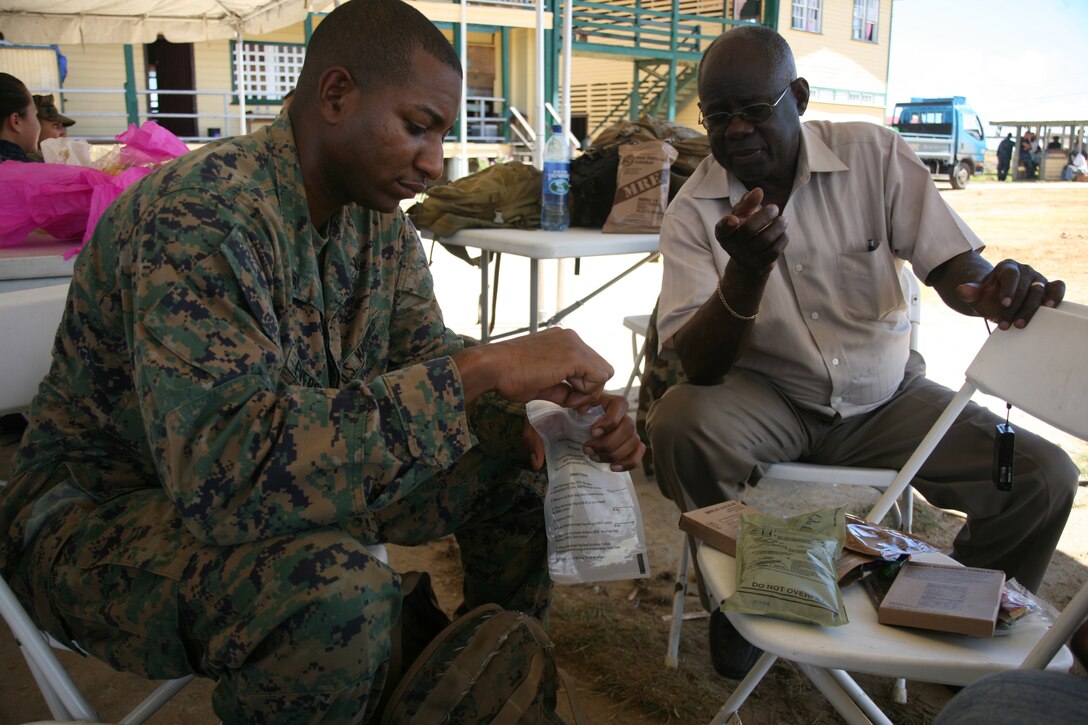 Cpl. John C. Eversley, a motor transportation operator with Special-Purpose Marine Air-Ground Task Force Continuing Promise 2010, shares lemonade from his field Meal Ready to Eat or MRE (field rations) with his Guyanese uncle, Thomas Eversley in Rose Hall, Guyana, Oct. 22. Cpl. Eversley had the unique opportunity to visit with his Guyanese family for an entire day while the civic-humanitarian assistance mission Operation Continuing Promise 2010 that Eversley is currently serving on made a stopover in Guyana for 10 days.