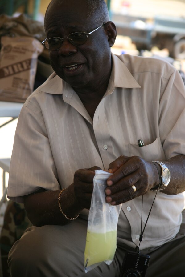Thomas Eversley, a Georgetown native shakes a bag of lemonade from his nephew Cpl. John C. Eversley's field rations. Cpl. Eversley had the unique opportunity to visit with his Guyanese family for an entire day in Rose Hill, Guyana, Oct. 22, while the civic-humanitarian assistance mission Operation Continuing Promise 2010 that Eversley is currently serving on made a stopover in Guyana for 10 days.