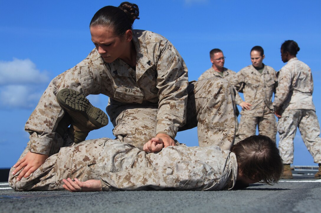 Corporal Jessica Ward, a Female Engagement Team (FET) member with Combat Logistics Battalion 26, 26th Marine Expeditionary Unit, searches Lance Cpl. Sarah Skiados during a class on the flight deck of USS Ponce, Oct. 22, 2010.  The FET is composed of female Marines who could be called upon to patrol with all male-units to interact with women in countries where women are restricted from speaking with men. 26th MEU is currently embarked aboard the ships of Kearsarge Amphibious Ready Group operating in the 5th Fleet area of responsibility.