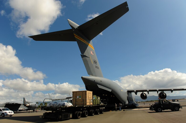 JOINT BASE PEARL HARBOR-HICKAM, Hawaii -- Airmen work to load a C-17 Globemaster III during Beverly Kahuna 2010-F, an Initial Response Readiness Exercise Oct. 20-21. During the exercise, more than 200 Airmen were processed through a deployment line, eight C-17 missions were generated and 140 short tons of cargo was moved while practicing the "deployment machine." This exercise concentrated on the basic "blocking and tackling" of getting cargo and people downrange. (U.S. Air Force photo/Staff Sgt. Mike Meares) 