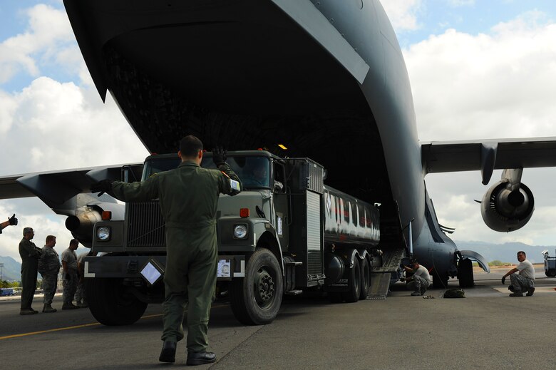 JOINT BASE PEARL HARBOR-HICKAM, Hawaii -- Airmen work to load a C-17 Globemaster III during Beverly Kahuna 2010-F, an Initial Response Readiness Exercise Oct. 20-21. During the exercise, more than 200 Airmen were processed through a deployment line, eight C-17 missions were generated and 140 short tons of cargo was moved while practicing the "deployment machine." This exercise concentrated on the basic "blocking and tackling" of getting cargo and people downrange. (U.S. Air Force photo/Staff Sgt. Mike Meares) 